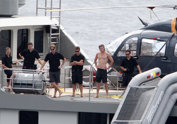 chris hemsworth shows off body with crew next to superyacht plan b's huge waterslide and helicopter
