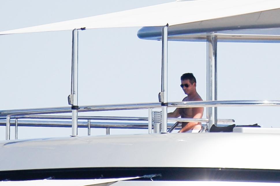 Simon Cowell cuts a lonely figure away from the crowds aboard Slipstream